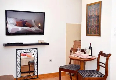 a living room with a table and a bed at Studio Milan in Vračar (historical)