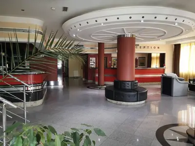 a lobby with a fireplace in the middle of a building at Hotel Elegance in Belgrade