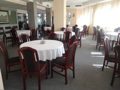 a dining room filled with tables and chairs with white tables at Hotel Elegance in Belgrade