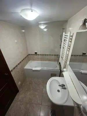 a bathroom with a sink and a tub and a toilet at Hotel Elegance in Belgrade