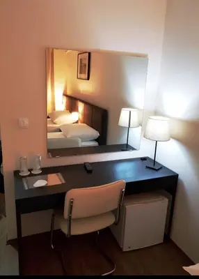 a desk in a hotel room with a mirror at Hotel Villa Panorama in Belgrade