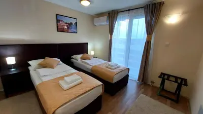 two beds in a hotel room with a window at Hotel Villa Panorama in Belgrade
