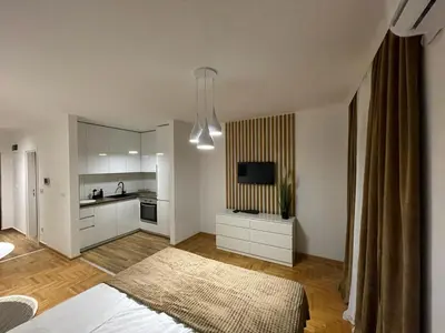 a living room with a bed and a kitchen at LL65 Apartmens Airport Nikola Tesla in Ledine