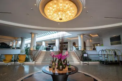 a lobby with a large chandelier and a table with flowers at Hyatt Regency Belgrade in Belgrade