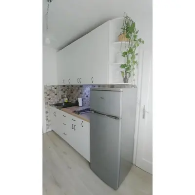 a kitchen with white cabinets and a sink at Kennedy apartment in Tošin Bunar