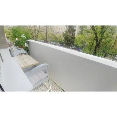 a balcony with a table and chairs and a window at Kennedy apartment in Tošin Bunar