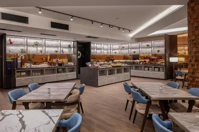 a restaurant with tables and chairs and a buffet at Nobel Design Hotel in Belgrade