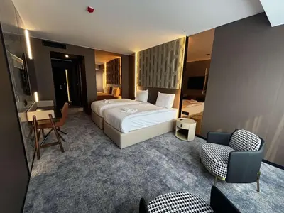 a hotel room with a large bed and a chair at Nobel Design Hotel in Belgrade