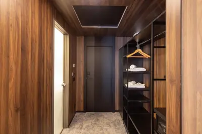 a walk in closet with wood paneling and a door at Nobel Design Hotel in Belgrade