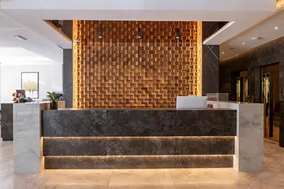 a lobby with a marble counter and a brick wall at Nobel Design Hotel in Belgrade