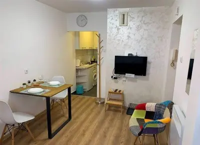 a living room with a table and chairs and a tv at Cozy & fully equipped studio in the heart of downtown and next to Kalemegdan in Belgrade