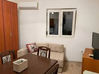 a living room with a table and a couch at Apartman u blizini centra grada in Belgrade