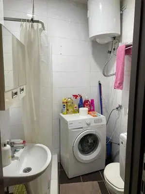 a bathroom with a washing machine and a sink at Apartman u blizini centra grada in Belgrade