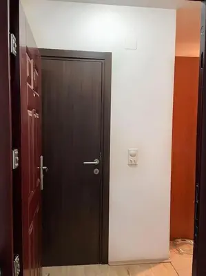 a hallway with a black door and a white wall at Apartman u blizini centra grada in Belgrade