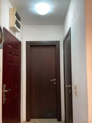 a hallway with two brown doors and a light at Apartman u blizini centra grada in Belgrade