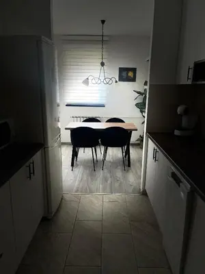 a kitchen with a table and chairs in a room at Apartman Darvin / Lux in Belgrade