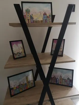 a wooden shelf with framed pictures on it at Apartman Darvin / Lux in Belgrade