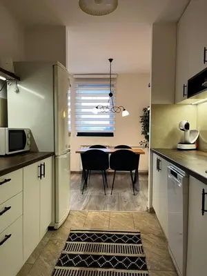 a kitchen and dining room with a table and chairs at Apartman Darvin / Lux in Belgrade