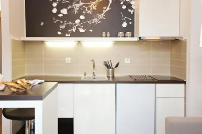 a kitchen with white cabinets and a sink at Boutique Apartments 360º in Belgrade