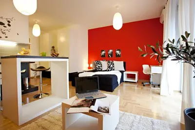a bedroom with red walls and a bed and a desk with a laptop at Boutique Apartments 360º in Belgrade
