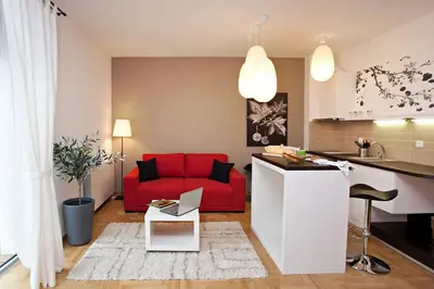 a kitchen and a living room with a red couch at Boutique Apartments 360º in Belgrade