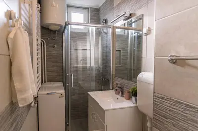 a bathroom with a toilet and a sink and a shower at Apartman Mila23 in Rospi Ćuprija