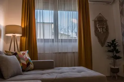 a living room with a couch and a large window at Apartman Mila23 in Rospi Ćuprija