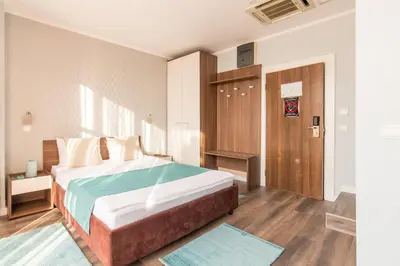 a bedroom with a large bed and a wooden door at Balkan Hotel Garni in Belgrade