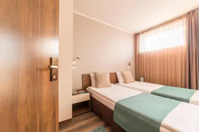 a hotel room with two beds and a window at Balkan Hotel Garni in Belgrade
