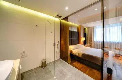 a bathroom with a bed and a glass shower at Apartments Belgrade in Belgrade