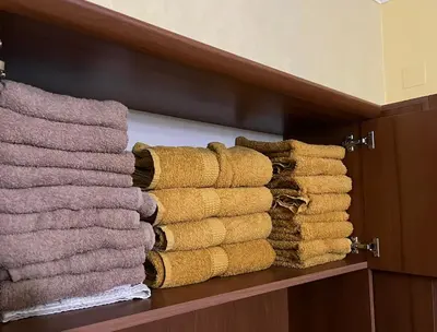 a pile of towels on a shelf in a bathroom at Dalmatinska Apartman in Belgrade