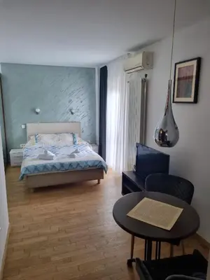a bedroom with a bed and a table and a chair at Dixy 2 in Belgrade