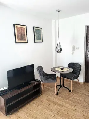 a living room with a tv and a table and chairs at Dixy 2 in Belgrade