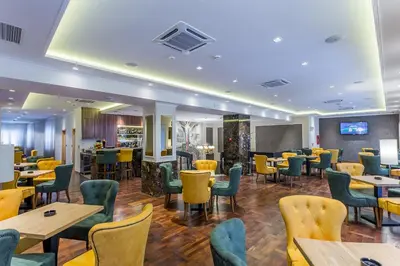 a restaurant with tables and chairs and a bar at Hotel Royal Inn in Belgrade