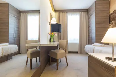 a hotel room with a desk and a bedroom at Hotel Royal Inn in Belgrade