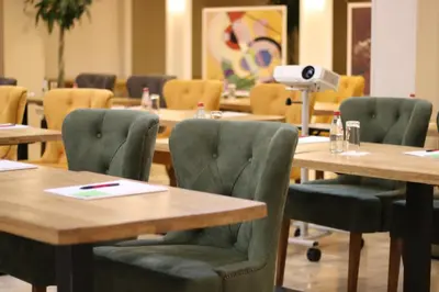 a conference room with tables and chairs with a projector at Hotel Royal Inn in Belgrade