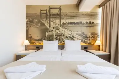 two beds in a hotel room with a mural at Hotel Royal Inn in Belgrade