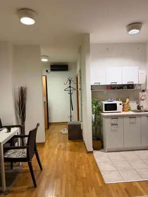 a kitchen with white cabinets and a table and a microwave at Belgrade with love in Novi Beograd