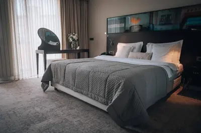 a bedroom with a large bed and a desk at Boutique Hotel Townhouse 27 in Belgrade