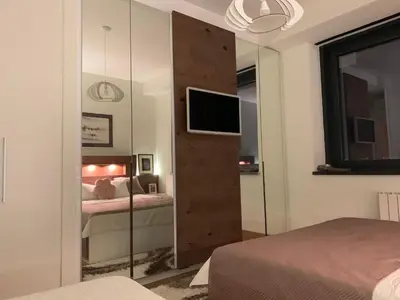 a bedroom with a sliding glass door with a television at Belgrade Waterfront Wolf in Sajmište