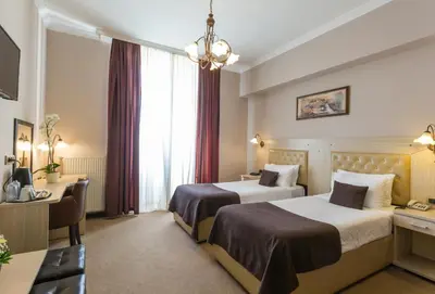 a hotel room with two beds and a desk at Belgrade City Hotel in Belgrade