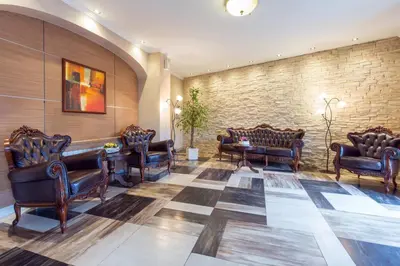 a waiting room with leather chairs and a brick wall at Belgrade City Hotel in Belgrade