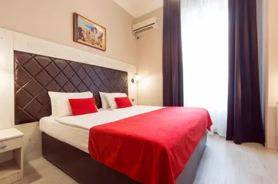 a bedroom with a large bed with a red blanket at Belgrade City Hotel in Belgrade