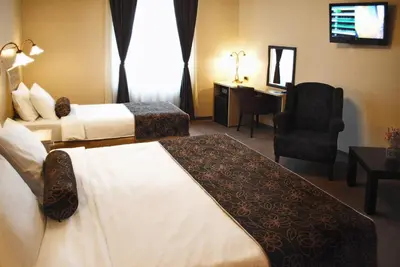 a hotel room with two beds and a chair at Belgrade City Hotel in Belgrade