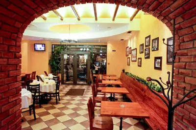 a restaurant with tables and chairs and a brick wall at Belgrade City Hotel in Belgrade