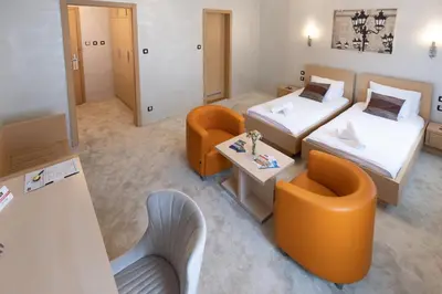 a hotel room with two beds and a couch at Euro Garni Hotel in Belgrade