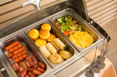 a tray of different types of food on a buffet at Euro Garni Hotel in Belgrade