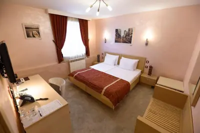 a hotel room with a bed and a desk at Euro Garni Hotel in Belgrade