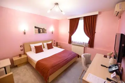 a bedroom with a bed and a desk and a computer at Euro Garni Hotel in Belgrade