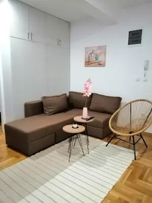 a living room with a brown couch and a table at MB apartman in Obrenovac